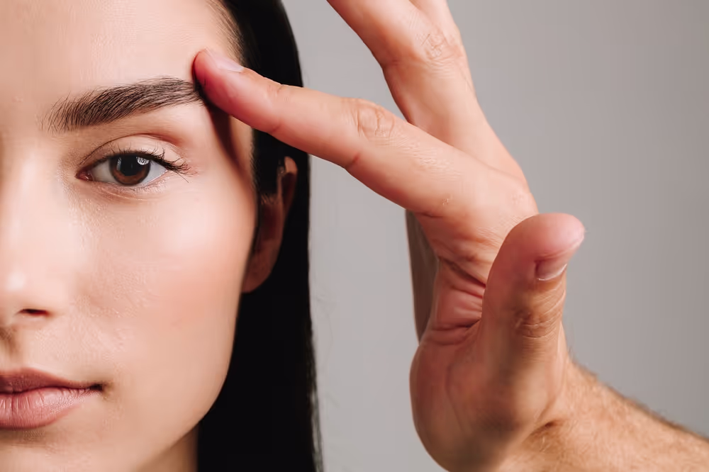 Mujer joven examinándose el rostro en el espejo