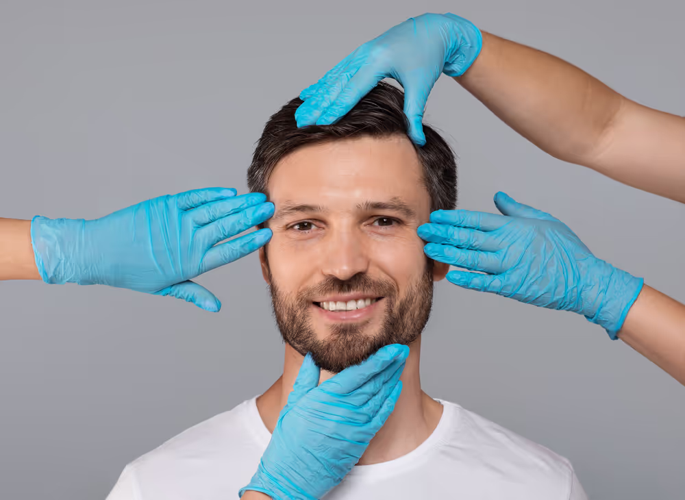 El rostro sonriente de un hombre es examinado por manos enguantadas.